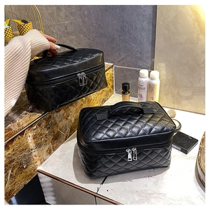 Detail of black quilted PU leather makeup bags with top handle and double zipper design