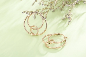 Detailed macro view of nested double hoop golden earrings with high-polish finish