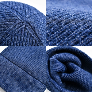 Dark blue ribbed knit beanie with rolled cuff and top stitching detail for winter warmth