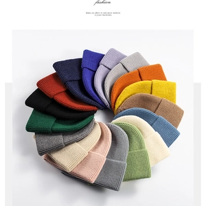 Flat lay of colorful ribbed knit beanies in various colors including orange and navy blue