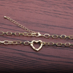 Gold hip-hop bracelet with hollow heart pendant and multicolored crystals on wood background