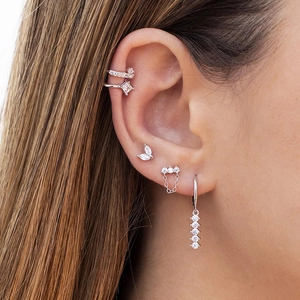 Detailed close-up of s925 silver earring set with zirconia crystals on a model's ear