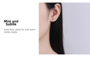 Close-up of mini S999 sterling silver ball stud earring worn on a model's earlobe