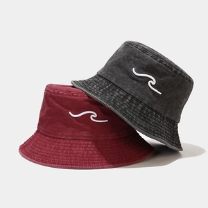 Detailed view of washed cotton bucket hats with 3D wave embroidery in grey and burgundy