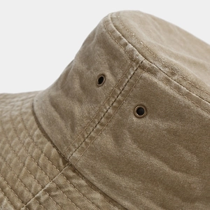 Detail of khaki washed canvas bucket hat featuring dual stitching and metal eyelets