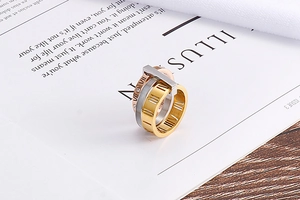Macro view of stacked stainless steel rings with Roman numerals and crystal inlays