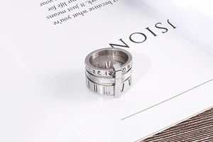 Macro detail of silver stainless steel tiered ring with Roman numerals and crystals