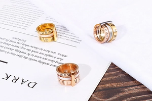 Macro view of Roman numeral stainless steel rings with shell inlay and zircon details
