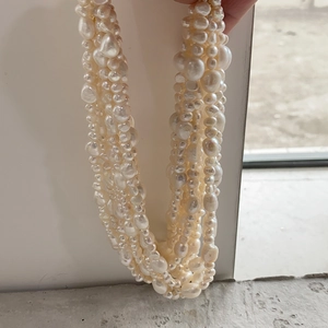 Detail of multilayered baroque freshwater pearl necklace with cream luster strands