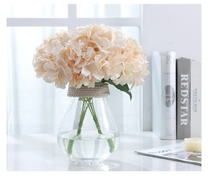Detail of 5-head champagne hydrangea silk flowers in a clear glass vase with hemp rope