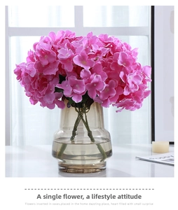 Lush pink artificial hydrangea in a transparent brown glass vase for home decoration