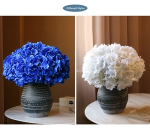 Detail of lifelike silk hydrangea petals in blue and white with textured ceramic vases
