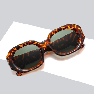 Chic tortoiseshell polygonal sunglasses with thick frames and dark grey lenses for street style