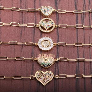 Golden hip hop paperclip bracelets with colorful zircon heart charms on wooden background
