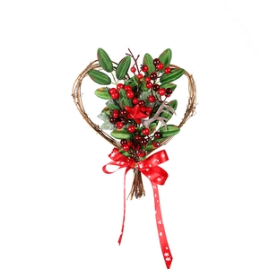 Christmas heart-shaped wreath with red berries, green leaves and pine cones on white background