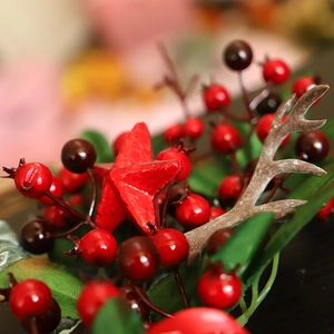 Christmas wreath decoration with red berries, wooden star and antlers for festive door decor