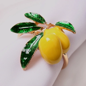 Detailed close-up of golden lemon napkin ring with yellow fruit and green leaves
