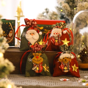 Christmas burlap gift bags set with cartoon Santa, snowman and deer on wood background