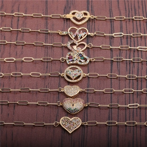 Hip Hop heart bracelets with gold plating and colorful cubic zirconia on wood background
