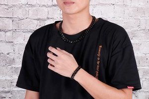 Gros plan d'un homme portant un ensemble collier et bracelet gourmette en acier noir