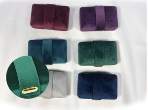 Detail of velvet jewelry boxes with gold metal buckles in various elegant colors