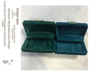 Detail view of velvet jewelry box with gold clasp and ring storage slots in green
