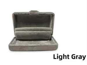 Macro view of light grey velvet jewelry box interior with golden clasp and ring slots