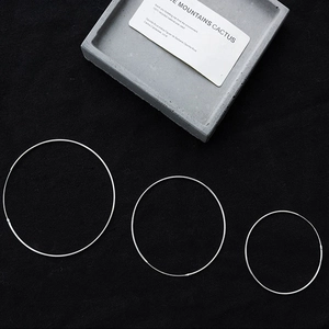 Detailed overhead view of three different sizes of minimalist S925 silver hoop earrings