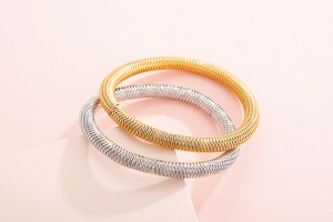 Detail of gold and silver spring-style bangles with fine spiral metal weave texture