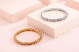 Macro detail of elastic spiral coil bangles in polished gold and silver finishes