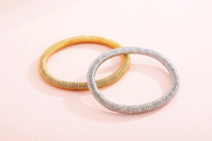 Detail of gold and silver stainless steel bangles with textured spiral design