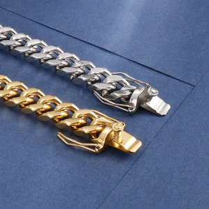 Detail of Cuban chain bracelets in gold and silver finish with secure clasp closure