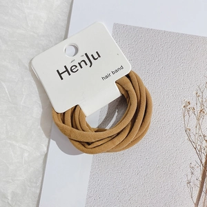 Detail showing set of brown high-elasticity hair bands on minimalist paper card