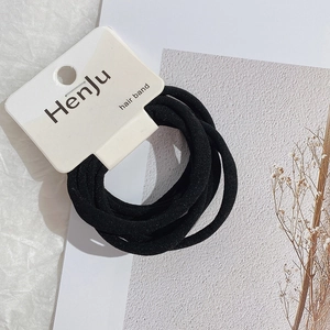 Close-up of black high-elastic hair bands with Henju brand card on textured background
