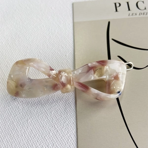 Detailed view of pink marble pattern acetate bow hair clip with high-quality metal buckle
