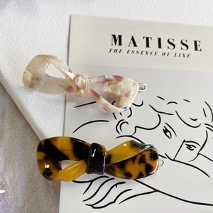 Close-up of elegant acetate bow hair clips in light and dark tortoiseshell patterns