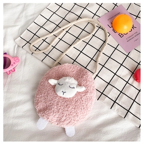 Detailed flat lay of pink plush lamb crossbody bag with soft textures and cute embroidery