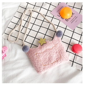Close-up of pink plush crown bag featuring golden star embroidery and soft pom-poms