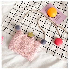 Detailed shot of a pink plush crown crossbody bag with gold sequins and grey pompom decor