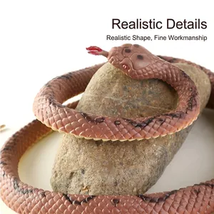 Realistic toy snake with brown and black patterns on a natural rock, lifelike texture