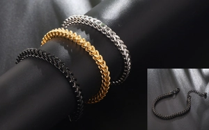 Close-up of titanium steel Franco chain bracelets in black, gold, and silver finishes