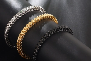 Three square-weave titanium steel bracelets in silver, gold, and black finishes
