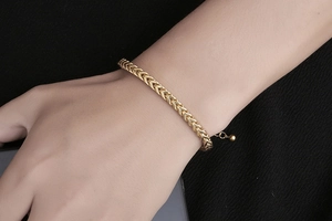 Detail of gold wheat chain stainless steel bracelet with adjustable clasp on wrist