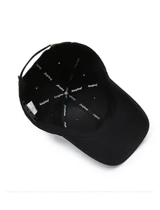 Detailed interior of a black cotton baseball cap showing seam reinforcement and wash tag