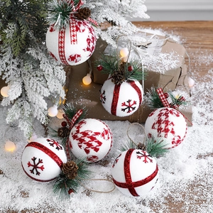 Three premium red and white Christmas foam ball ornaments with snowflake patterns on snow