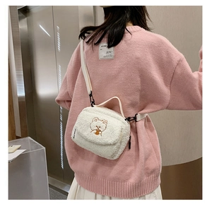 Cute white lamb wool shoulder bag with teddy bear embroidery shown on a model