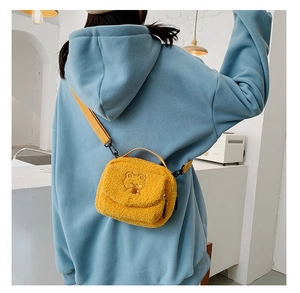 Detail of yellow fuzzy lamb fleece bag featuring a cute minimalist bear embroidery