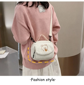 Detail of cute white fuzzy lamb wool crossbody bag with bear embroidery on a pink sweater
