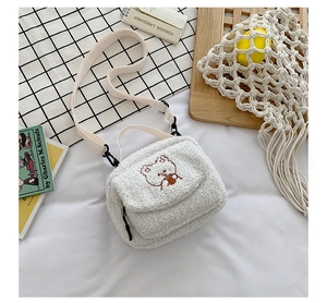 Detailed macro of the white lamb wool crossbody bag with cute embroidered bear design