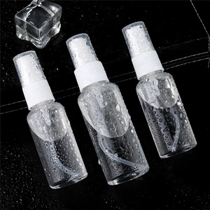 Three clear plastic spray bottles on a wet surface with fresh water droplets and ice cubes